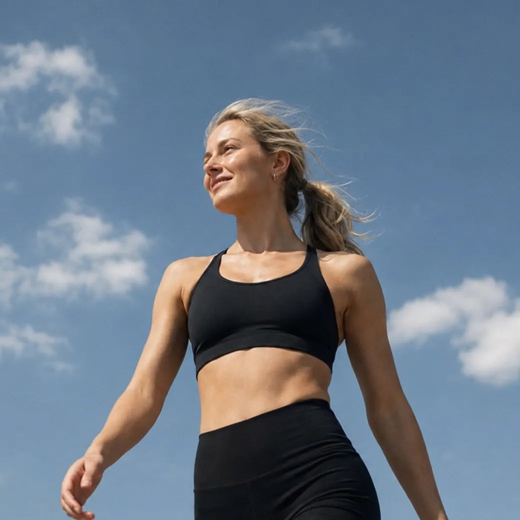 Woman walking outdoors under a blue sky